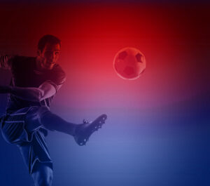 Football player kicking football on a red & blue background.